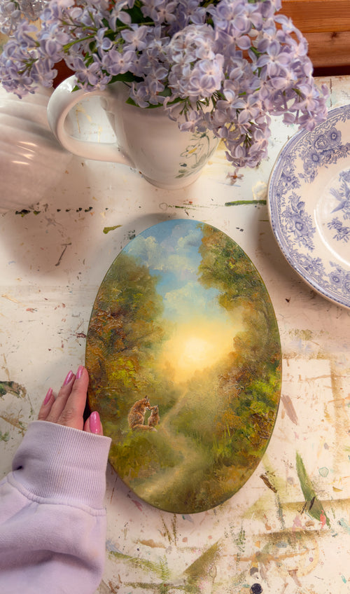 Original oval painting displayed on a table with lilac flowers and vintage tableware.