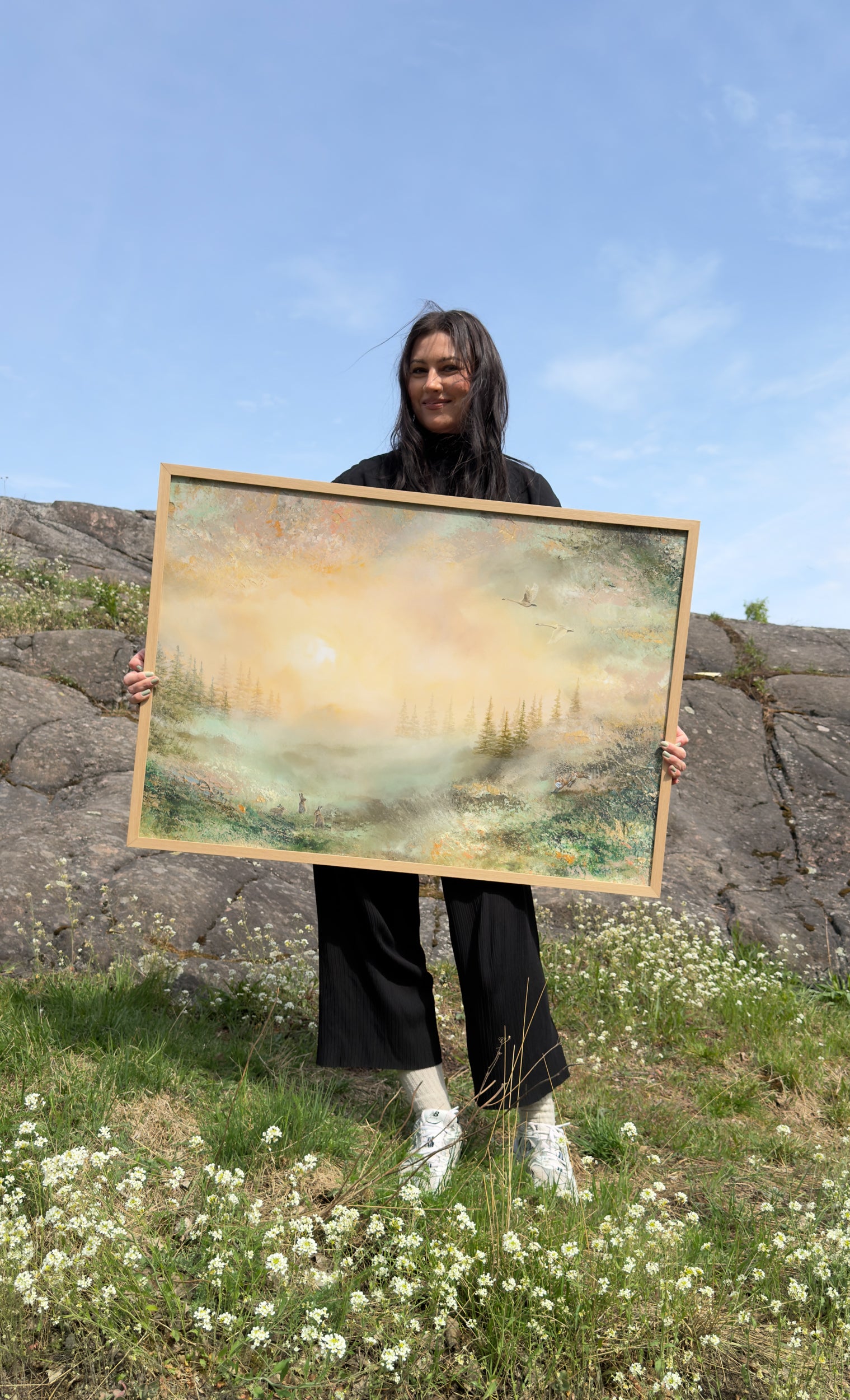 Jenni Inberg holding the framed fine art print to demonstrate its size.
